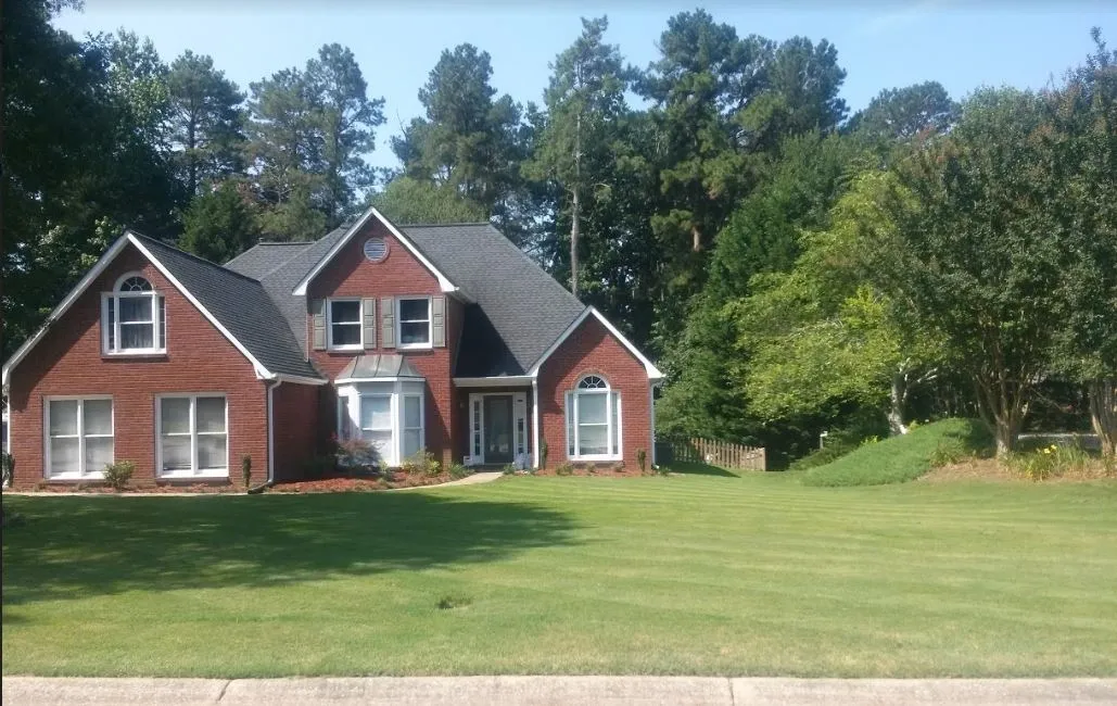 Mowed front lawn with a red brick house